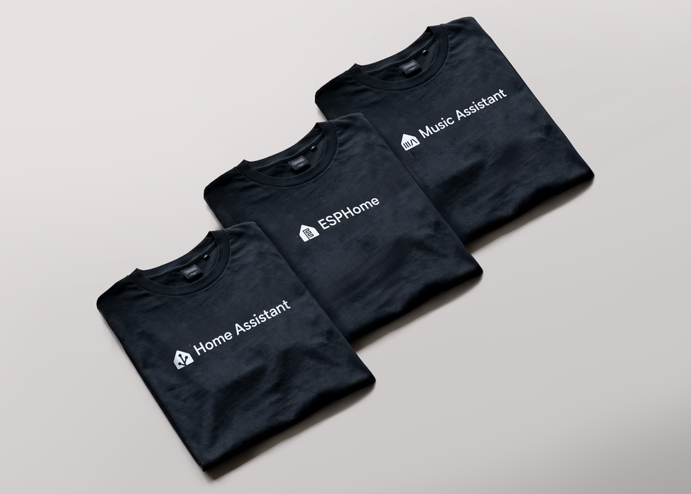 Three black T-shirts from the Open Home Foundation store, featuring the ESPHome, Music Assistant, and Home Assistant designs.